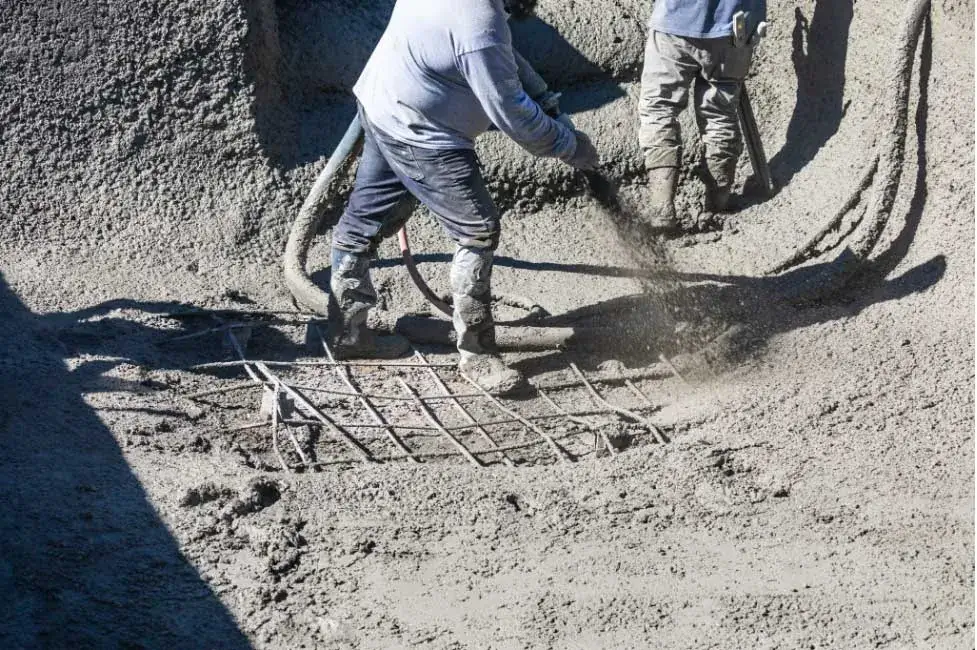 Pool builder applying shotcrete to pool shell