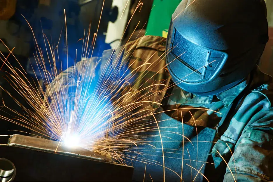 Welding subcontractor using a face shield during welding.